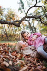 Portrait of small girl with grandmother on a walk in autumn forest, having fun. - HPIF21641