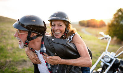 Ein fröhliches älteres Ehepaar reist mit dem Motorrad auf dem Land und hat Spaß. - HPIF21819