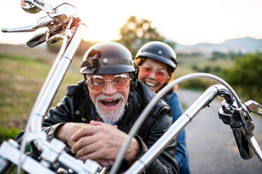 Ein fröhliches älteres Ehepaar reist mit dem Motorrad auf dem Land. Platz zum Kopieren. - HPIF21834