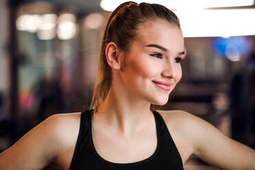 A portrait of a beautiful young girl or woman standing in a gym. - HPIF21877