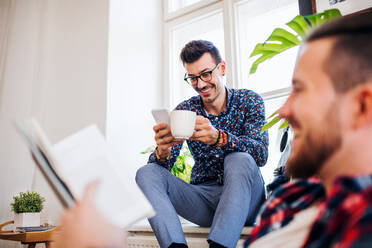 A group of young cheerful friends relaxing indoors, house sharing concept. - HPIF21913