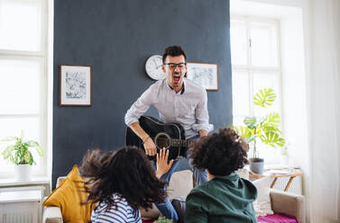 Eine Gruppe junger, fröhlicher Freunde mit Gitarre im Haus, Konzept der Hausgemeinschaft. - HPIF21953