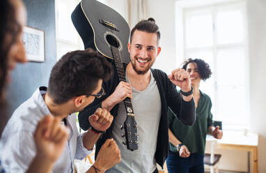 Eine Gruppe junger, fröhlicher Freunde mit Gitarre im Haus, Konzept der Hausgemeinschaft. - HPIF21955