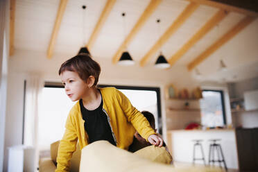 A happy small girl playing on sofa at home. - HPIF22036