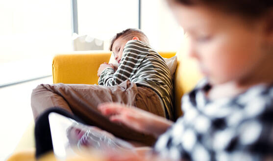 Zwei Kinder verbringen ihre Zeit auf einem Sofa zu Hause. - HPIF22063