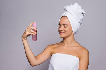 A portrait of a young woman with spray in a studio, beauty and skin care concept. - HPIF22113