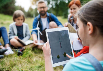 Eine Gruppe von Schulkindern mit Lehrer und Windmühlenmodell auf einem Ausflug in die Natur. - HPIF22137