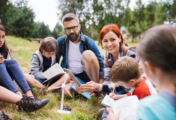 A group of school children with teacher and windmill model on field trip in nature. - HPIF22138