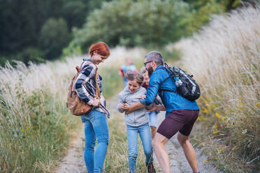 A group of small school children with teacher on field trip in nature, running. - HPIF22153