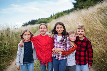 Porträt einer Gruppe von Schulkindern auf einem Ausflug in die Natur, die in die Kamera schauen. - HPIF22157