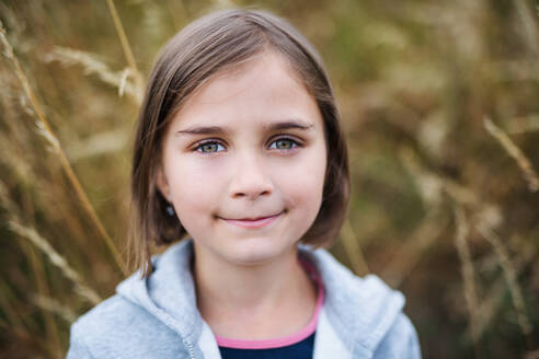 Portrait of school child standing on field trip in nature, looking at camera. - HPIF22161