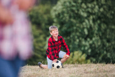 Schulkinder, die auf einem Ausflug in der Natur stehen und mit einem Ball spielen, Kopierraum. - HPIF22170