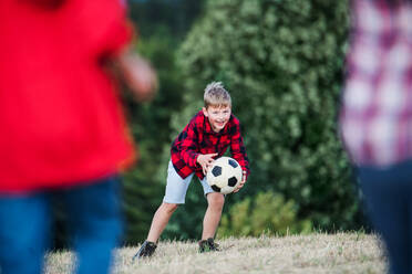 Portrait of group of school children standing on field trip in nature, playing with a ball. - HPIF22171