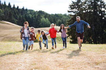 Eine Gruppe von kleinen Schulkindern mit Lehrer auf Exkursion in der Natur, beim Laufen. - HPIF22184