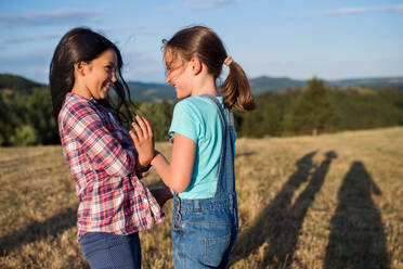 Two cheerful school children walking on field trip in nature, playing. - HPIF22199