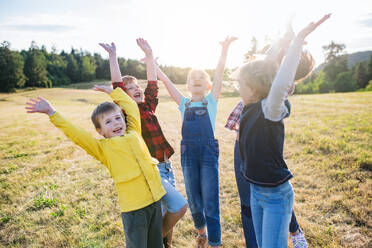 Porträt einer Gruppe von Schulkindern, die auf einem Ausflug in der Natur stehen und spielen. - HPIF22202