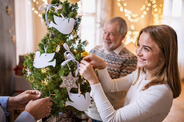 Glückliche Männer und Frauen Familie Verwandten drinnen zu Hause an Weihnachten, Dekorieren Baum. - HPIF22250