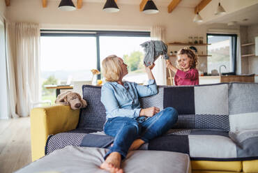 A happy cute small girl with mother indoors at home, playing. - HPIF22365