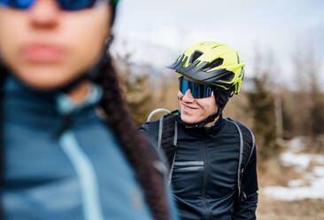 Zwei Mountainbiker stehen im Winter auf einer Straße im Freien und ruhen sich aus. - HPIF22435