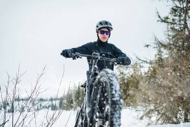 Eine Frontansicht von Mountainbiker Reiten im Schnee im Freien im Winter Natur. - HPIF22456