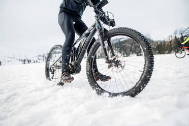 Ein Mittelteil eines Mountainbikers, der im Winter draußen im Schnee fährt. - HPIF22461