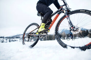 Ein Mittelteil eines Mountainbikers, der im Winter draußen im Schnee fährt. - HPIF22463