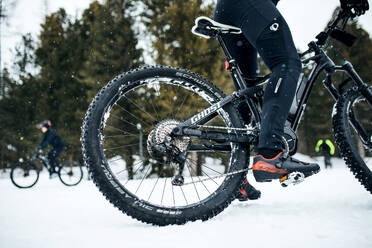 Ein Mittelteil eines Mountainbikers, der im Winter draußen im Schnee fährt. - HPIF22490