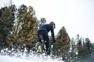 Eine Rückansicht von Mountainbiker fahren im Schnee im Freien im Winter Natur. - HPIF22494