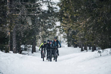 Eine Gruppe junger Mountainbiker fährt im Winter auf der Straße. - HPIF22498