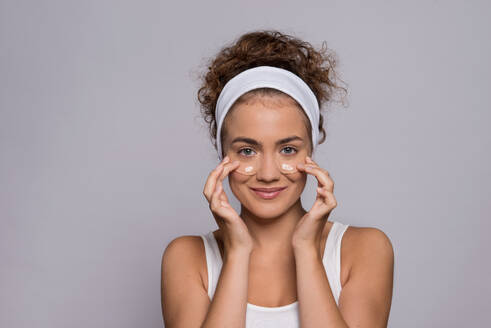 Porträt einer jungen Frau mit Kollagenpads unter den Augen in einem Studio, Schönheit und Hautpflege. - HPIF22504