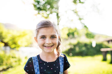 A portrait of a small happy girl in the garden in spring nature. Copy space. - HPIF22587