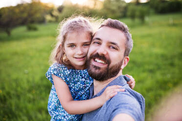 Father with a small daughter having fun in sunny spring nature, taking selfie. - HPIF22626