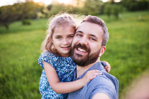 Ein Vater und seine kleine Tochter genießen den Frühling in der freien Natur und halten den Moment mit einem Selfie fest - HPIF22626