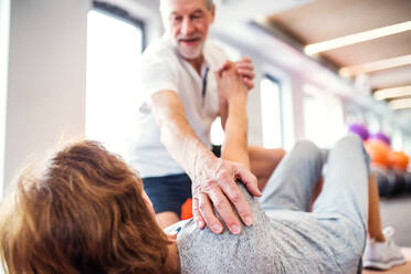 Senior physiotherapist working with an old female patient. - HPIF22653