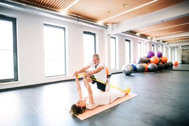 Senior male physiotherapist working with a young female patient. - HPIF22662