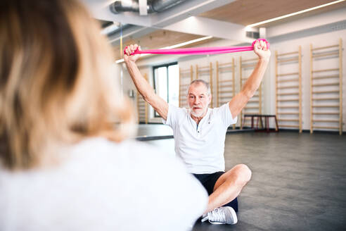 Ältere Physiotherapeutin bei der Arbeit mit einer nicht zu erkennenden Patientin. - HPIF22673