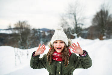 Porträt eines kleinen Mädchens in winterlicher Natur, mit Mantel, Mütze und Schal. - HPIF22705