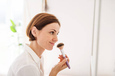 A morning routine of young woman putting on a make-up in a bathroom. - HPIF22874