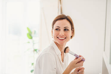 A morning routine of young woman putting on a make-up in a bathroom. - HPIF22877