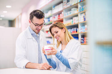 Two friendly pharmacists working in a drugstore. - HPIF22989