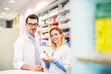 Two friendly pharmacists working in a drugstore. - HPIF22990