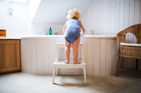 Kleiner Junge steigt in eine Badewanne. Häuslicher Unfall. Gefährliche Situation im Badezimmer. Rückansicht. - HPIF23052