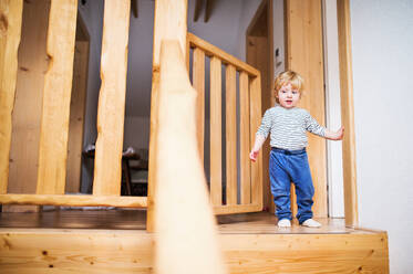 Kleines Kleinkind auf der Treppe stehend. Häuslicher Unfall. Gefährliche Situation zu Hause. Kindersicherheitskonzept. - HPIF23128