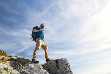 Reifer Mann mit Rucksack, der im Sommer in den Bergen wandert, Kopierraum. - HPIF23251