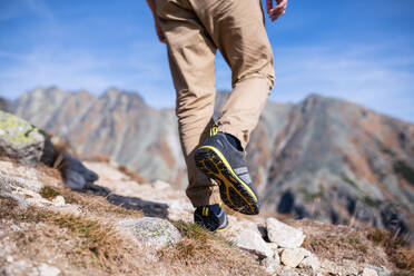 Legs of unrecognizable hiking in mountains in summer, walking. - HPIF23255