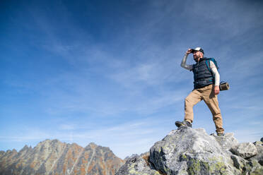 Reifer Mann mit Rucksack, der im Sommer in den Bergen wandert, Kopierraum. - HPIF23271