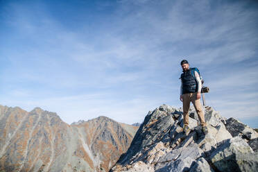 Reifer Mann mit Rucksack, der im Sommer in den Bergen wandert, Kopierraum. - HPIF23275