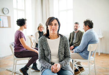 A portrait of senior depressed woman during group therapy. - HPIF23314