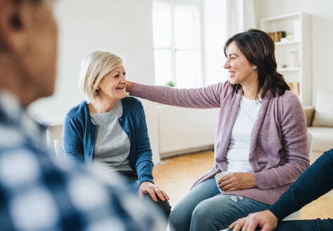 Seriöse Männer und Frauen, die während einer Gruppentherapie im Kreis sitzen und sich gegenseitig unterstützen. - HPIF23351