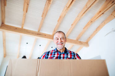 Ein Low-Winkel-Porträt von älteren Mann holdig Karton bei der Einrichtung eines neuen Hauses, ein neues Zuhause Konzept. kopieren Raum. - HPIF23504